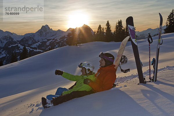 Frau Berg Winter Mann Snowboard Snowboarding Sonnenuntergang schnitzen Alpen Skisport Ski Außenaufnahme Tiefschnee Wintersport