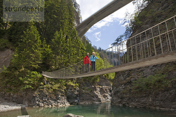 Hängebrücke Frau Mann gehen Weg Brücke wandern Schlucht Kanton Graubünden Wanderweg trekking