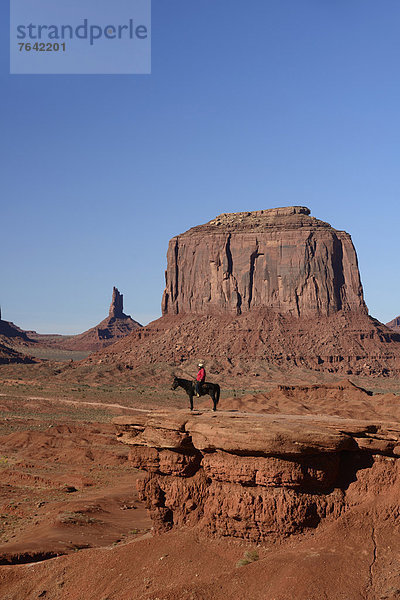 Vereinigte Staaten von Amerika  USA  Hochformat  Mann  Amerika  am Tisch essen  fahren  Reise  Fäustling  Indianer  Nordamerika  Arizona  Süden  Reiter  Ethnisches Erscheinungsbild  Kayenta  Arizona  Monument Valley  Navajo  Sandstein