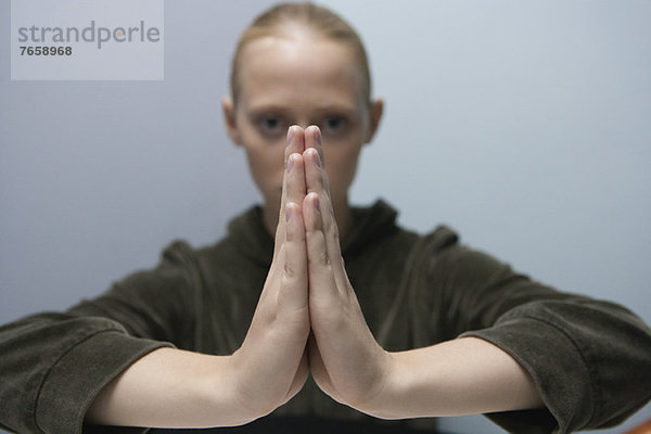 Junge Frau mit im Gebet gefesselten Händen
