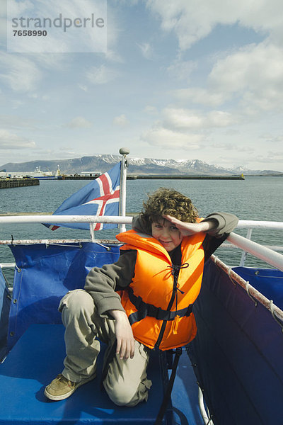 Junge in einer Schwimmweste auf einem Boot  Reykjavik Island