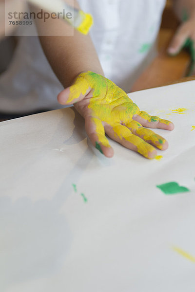 Kinderhand mit Farbe überzogen