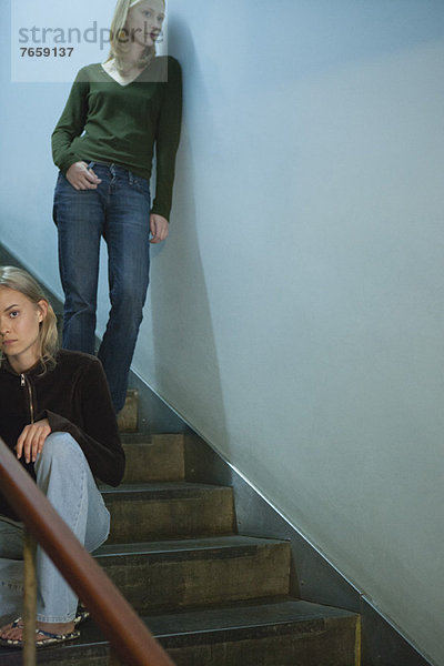 Teenagerin auf der Treppe sitzend  junge Frau lehnt sich an der Wand hinter sich her