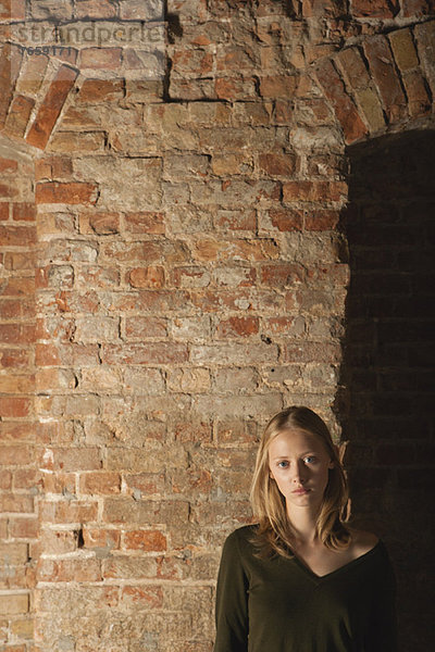 Junge Frau vor Backsteinmauer  Portrait