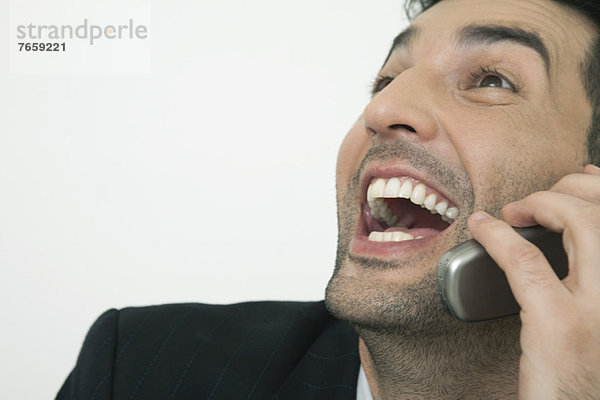 Mittlerer Erwachsener Geschäftsmann  der lacht  während er mit dem Handy redet.