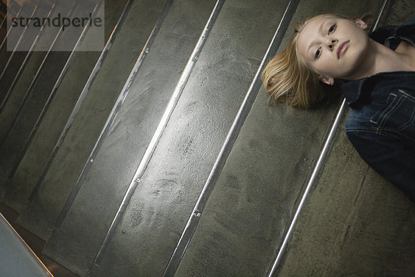 Junge Frau auf der Treppe liegend