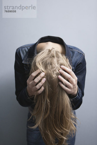 Junge Frau bückt sich  wirft Haare.