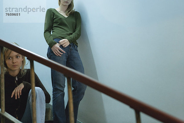 Teenagerin auf der Treppe sitzend  junge Frau lehnt sich an der Wand hinter sich her