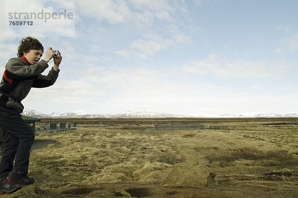 Junge fotografiert die Gullfoss-Landschaft  Island