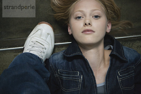 Junge Frau auf dem Boden neben einem Schuh liegend  Portrait