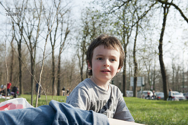 Junge sitzt im Park