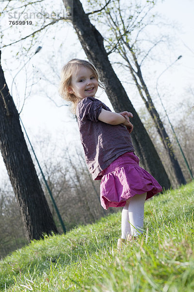 Kleines Mädchen lächelt im Freien  Ganzkörperporträt