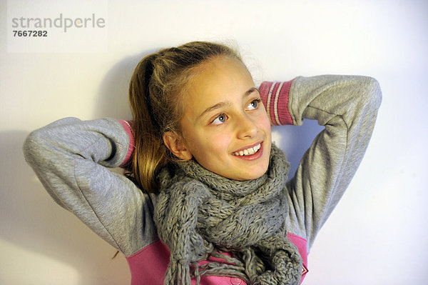Mädchen  10 Jahre  lächelt  Arme hinter dem Kopf verschränkt