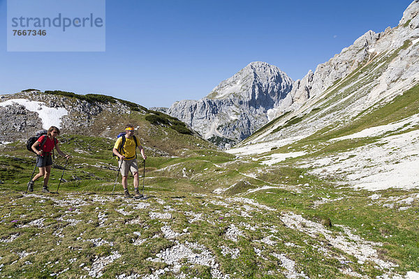 Ein Mann und eine Frau beim Wandern  Aufstieg von der Berghütte Vodnikov dom zum Triglav  Nationalpark Triglav  Slowenien  Europa