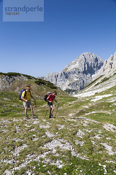 Ein Mann und eine Frau beim Wandern  Aufstieg von der Berghütte Vodnikov dom zum Triglav  Nationalpark Triglav  Slowenien  Europa