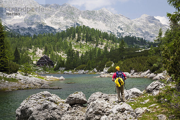 Ein Mann beim Wandern  blickt auf die Koca pri Triglavskih jezerih  Sieben-Seen-Hütte  Nationalpark Triglav  Slowenien  Europa