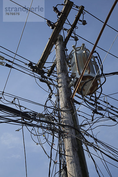 Elektrische Kabel und Telefonleitungen an einem Strommast