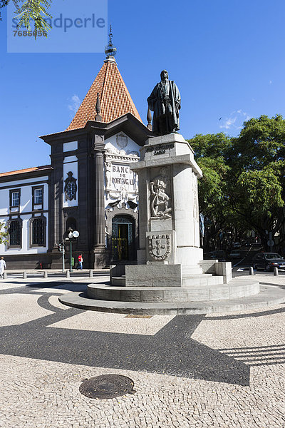 Die Banco de Portugal mit Denkmal von Joao Goncaves Zarco  Av Arriaga in der Altstadt von Funchal