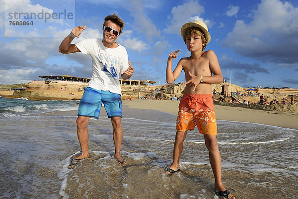 Zwei Jungen rappen am Strand  vor Cala Comte  Platges de Comte  Ibiza  Pityusen  Balearen  Spanien  Europa