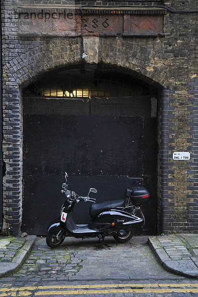 Eingang zu einer alten Lagerhalle in der Blossom Street  davor ein geparkter Motorroller