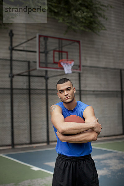 Mann steht auf dem Basketballplatz