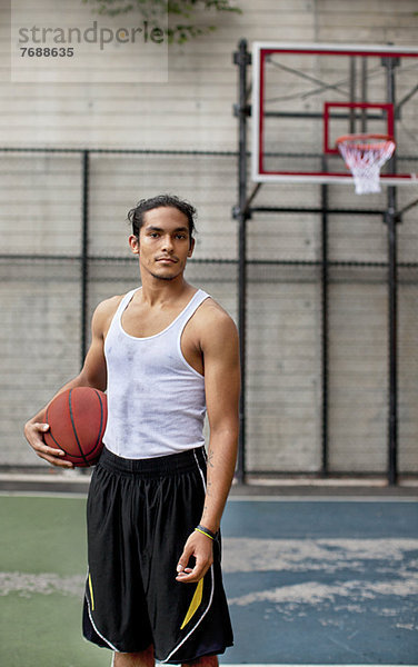 Mann steht auf dem Basketballplatz