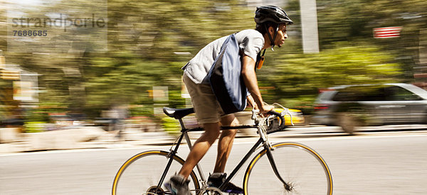 Mann fährt Fahrrad auf der Stadtstraße