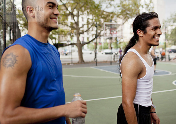 Männer lachen auf dem Basketballplatz