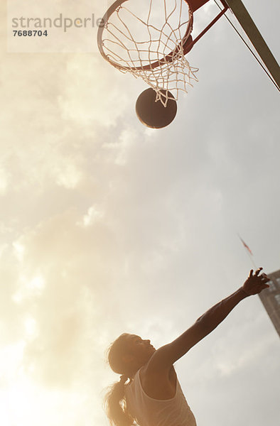 Mann spielt Basketball auf dem Platz