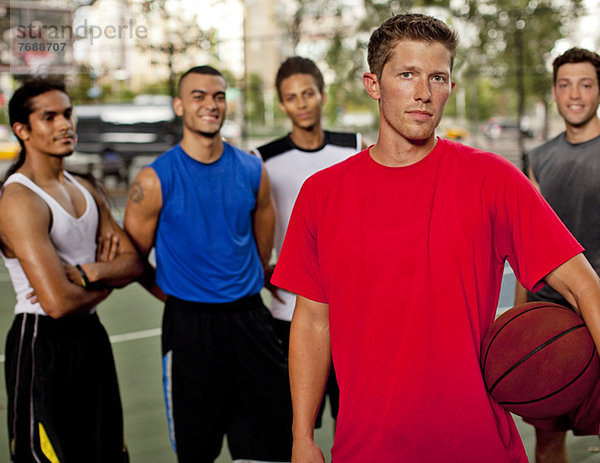 Männer stehen auf dem Basketballplatz