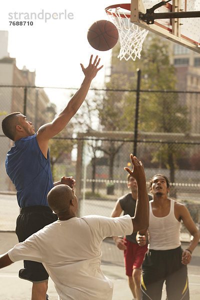 Männer spielen Basketball auf dem Platz