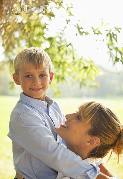 Mutter und Sohn umarmen sich im Park