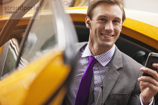 Geschäftsmann beim Aussteigen aus dem Taxi