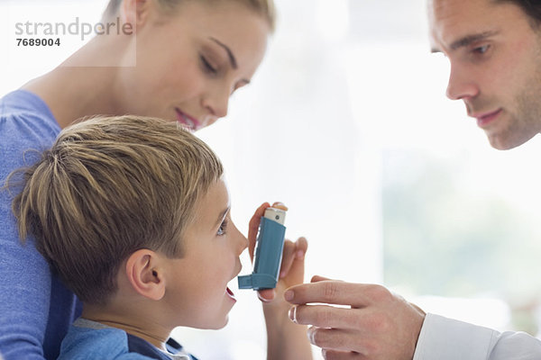 Eltern  die Sohn Asthma-Inhalator geben