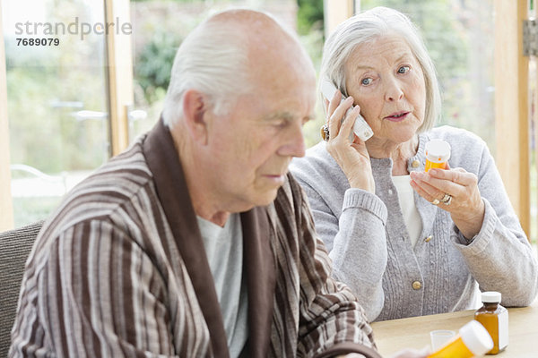 Ältere Frau mit Medikamenten am Telefon