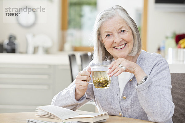Ältere Frau trinkt Tee und liest