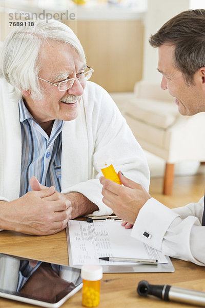 Arzt  der älteren Patienten beim Hausbesuch Medikamente verabreicht.