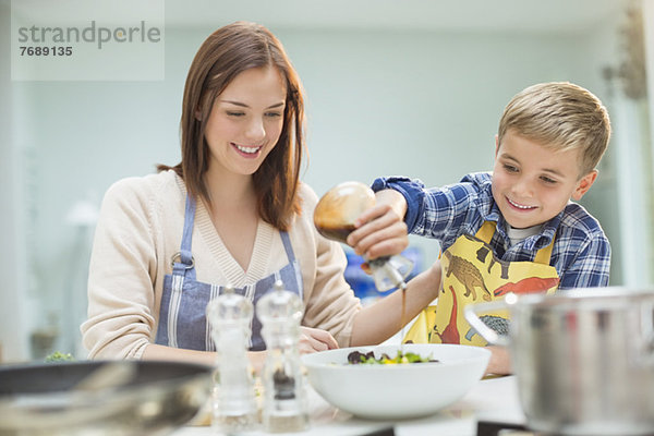 Mutter und Sohn machen Salat in der Küche