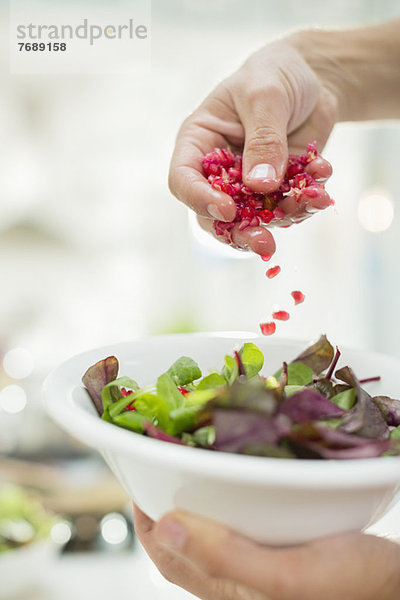 Frau macht Salat in der Küche