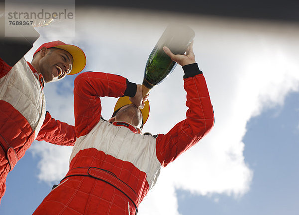 Racer trinkt Champagner auf der Strecke