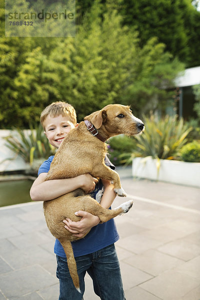 Lächelnder Junge mit Hund im Freien