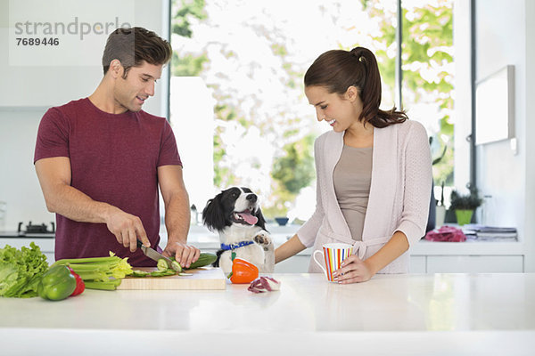 Hund mit Paar Kochen in der Küche