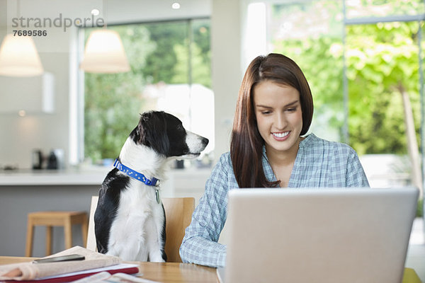 Hunde beobachtende Frau benutzt Laptop