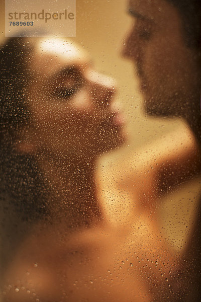 Nacktes Paar beim Küssen unter der Dusche