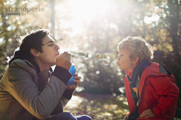 Vater und Sohn beim Blasenblasen im Park