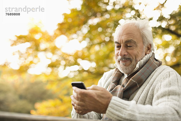 Älterer Mann mit Handy im Freien