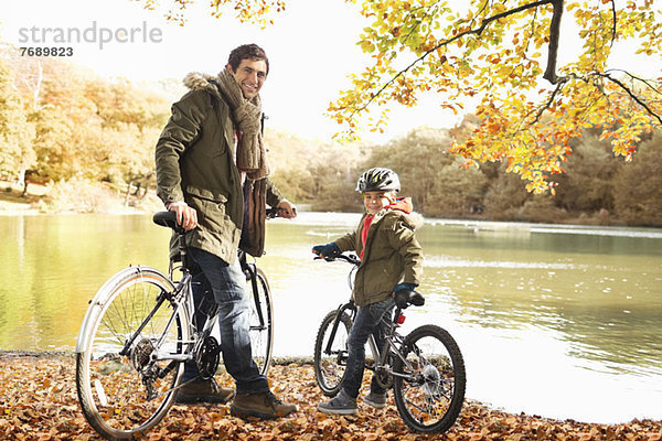 Vater und Sohn sitzen auf Fahrrädern im Park
