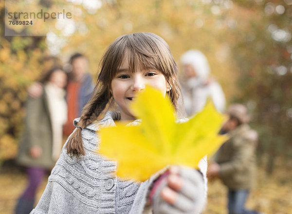 Mädchen mit Herbstblatt im Park