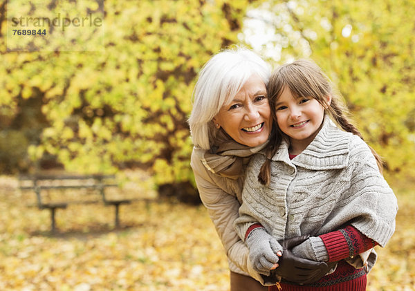 Ältere Frau und Enkelin lächelnd im Park