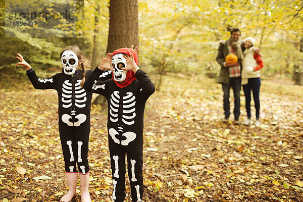 Kinder in Skelettkostümen wandern im Park